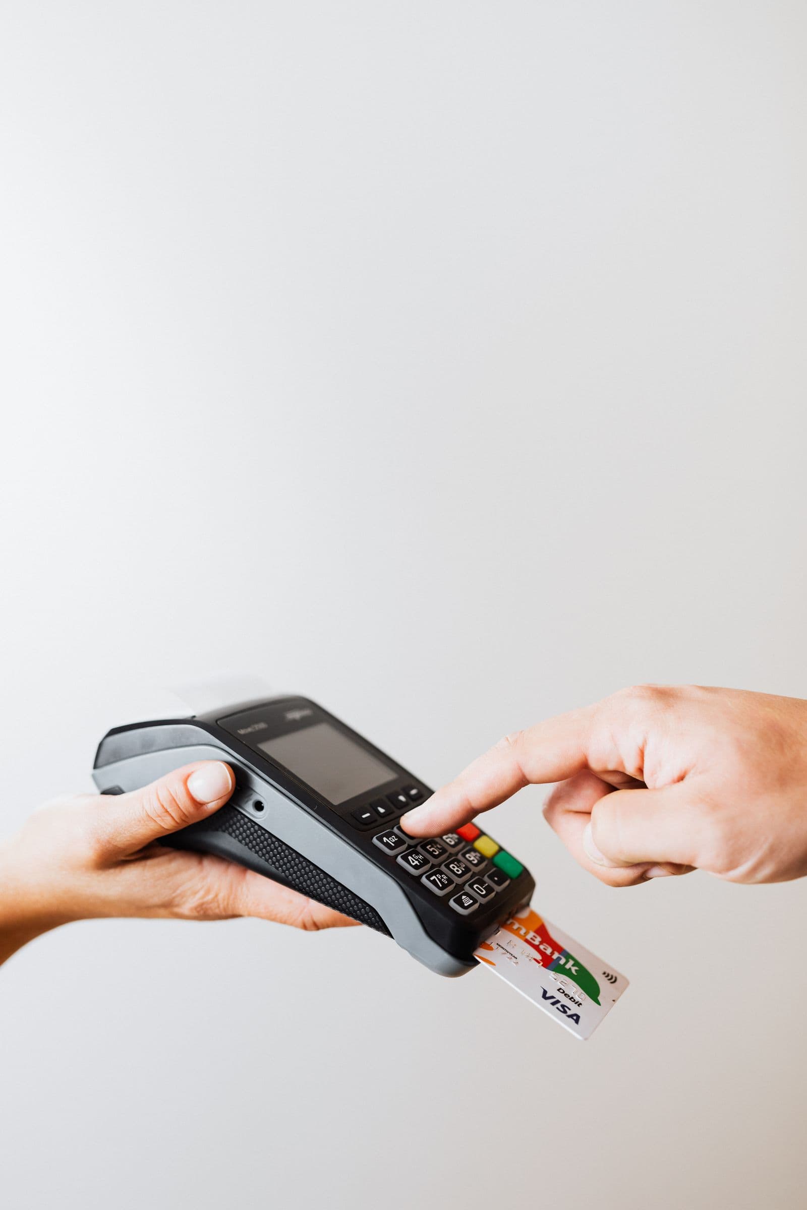 Hand tapping a card on a payment terminal